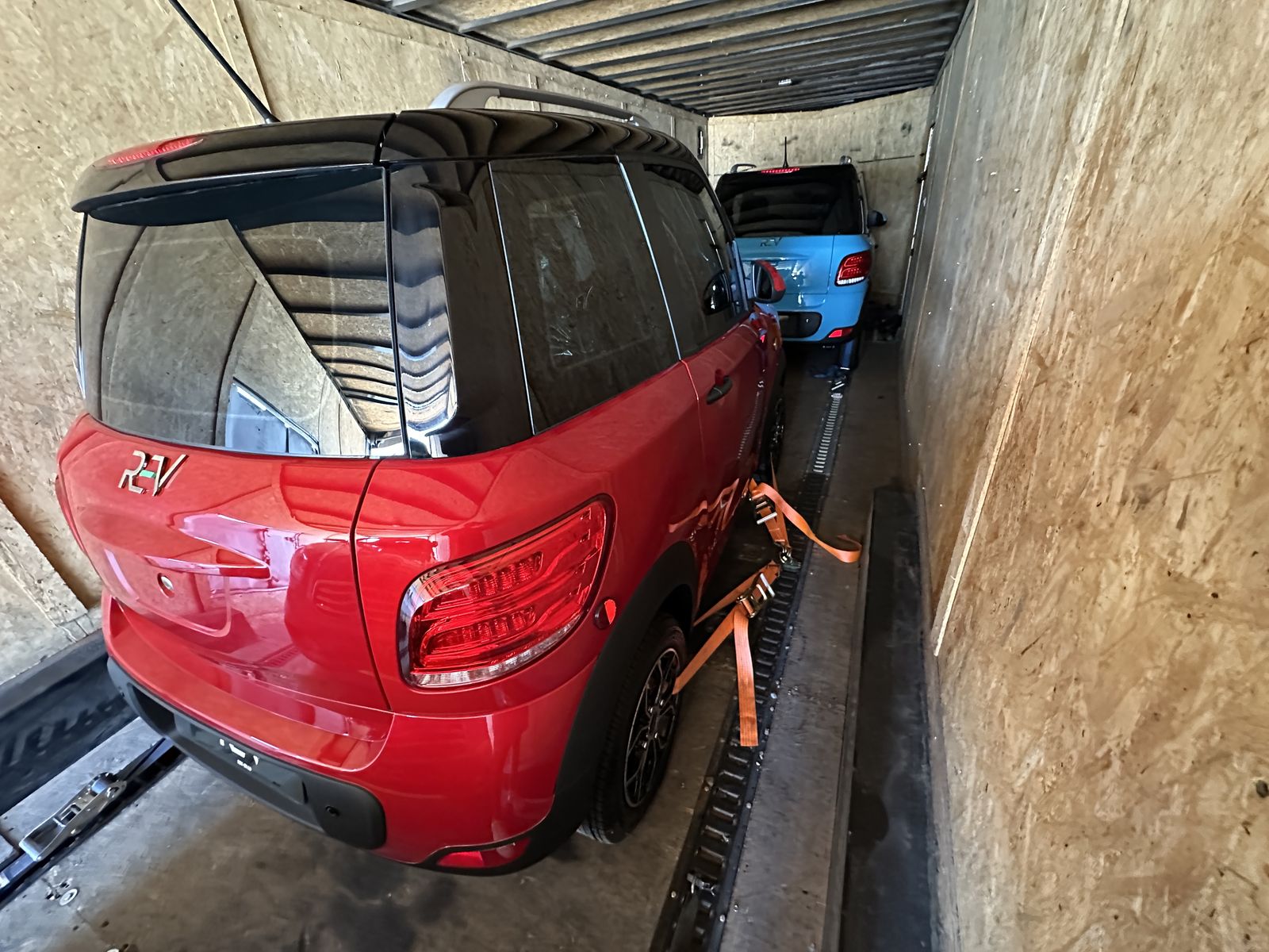 Red and blue REV M2 units secured together inside an enclosed trailer