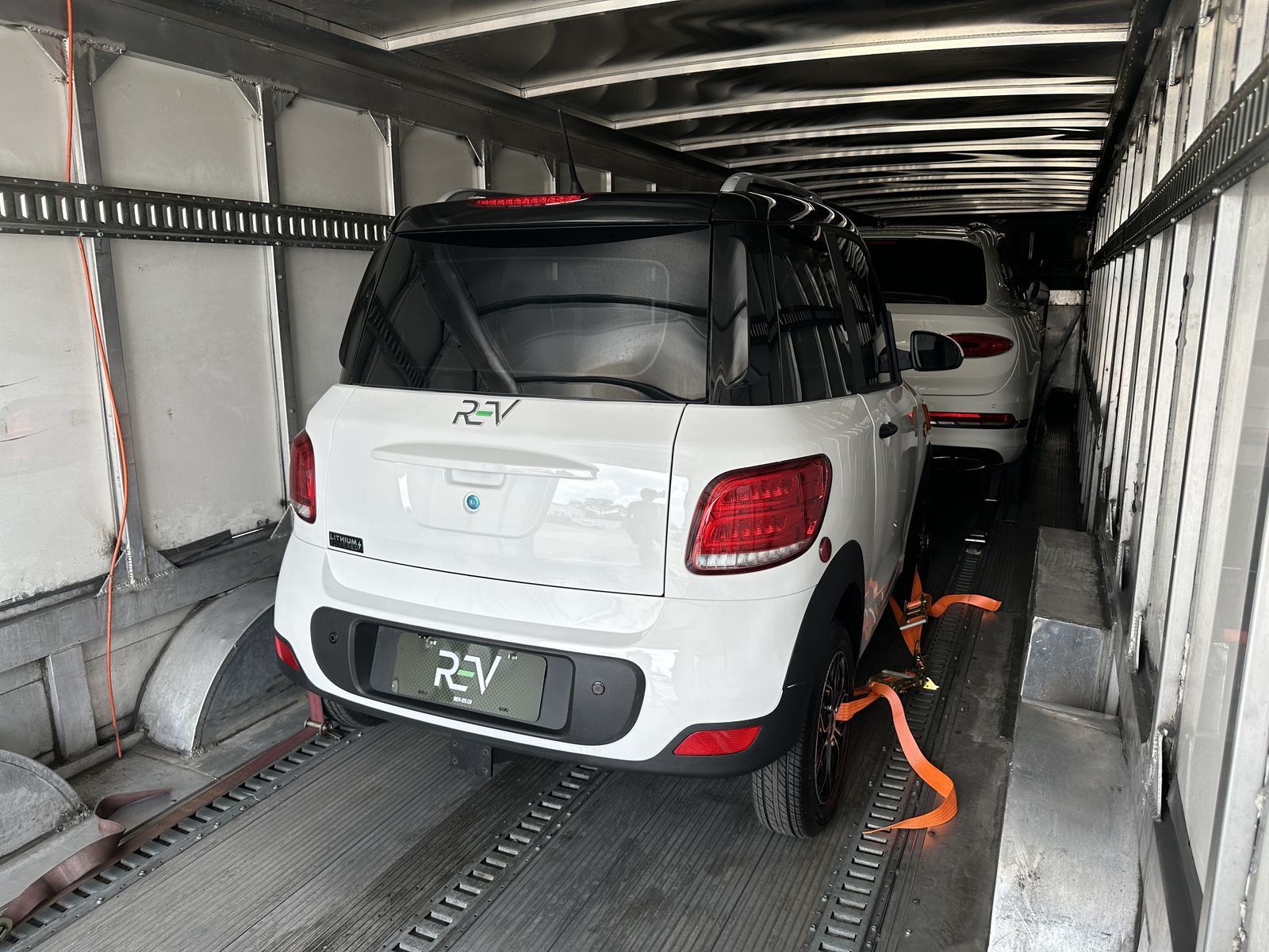 White REV M2 secured inside an aluminum-walled enclosed trailer