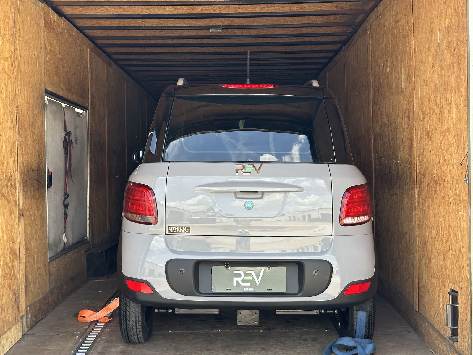 REV M2 secured inside a wood-paneled enclosed trailer